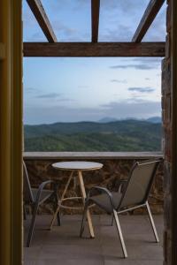 una mesa y sillas en un balcón con vistas en Foresta in Medias Mores en Vlakhokeraséa