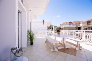 a balcony with a white table and bench on a building at Villy Suites in Argassi