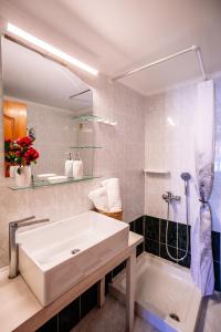 un bagno con ampia vasca bianca e lavandino di Villy Suites ad Argásion