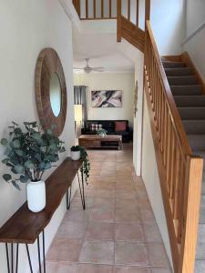 a living room with a staircase and a mirror at Fairway View in Dunsborough