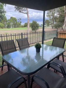 una mesa con sillas y una maceta en un patio en Fairway View, en Dunsborough