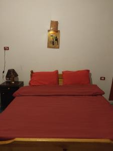 a bedroom with a red bed with red pillows at اللوكاندة الجديدة New Hotel in Alexandria