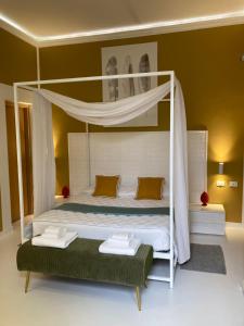 a bedroom with a white bed with a canopy at B&B Palazzo Diaz in Marsala