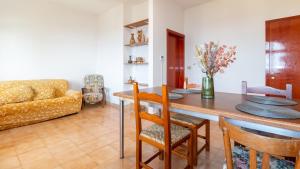 uma sala de estar com uma mesa e um sofá em La Rosa dei Venti-Panoramic View em S'archittu Cuglieri