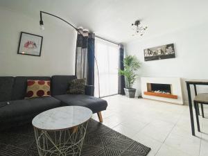 een woonkamer met een bank en een tafel bij 3 Bedroom flat in Hockley Birmingham near city centre, comfy and convenient in Birmingham