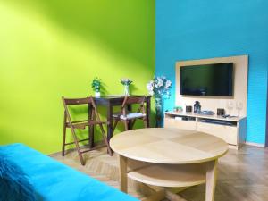 a living room with a table and a green wall at Józefa 2 by Homeprime in Krakow