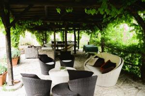 a group of chairs and tables under a pergola at B&B A Casa Mia in Marostica