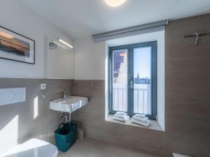 ein Bad mit einem Waschbecken und einem Fenster in der Unterkunft StadtQuartier in Malchow
