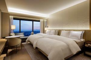 a bedroom with two beds and a large window at The Westin Yokohama in Yokohama