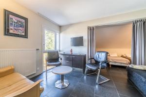 a hotel room with a bed and a table and chairs at Gîte Le Jorat - Appartement A in Bogève