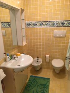 uma casa de banho com um lavatório e um WC em Attico sul Porto Vecchio - Lampedusa em Lampedusa