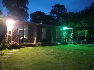 a house with a lit up yard at night at Rancho dos Pássaros Amarelos in Campestre