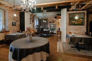 un restaurant avec deux tables et une salle à manger dans l'établissement Piena muiža - Berghof Hotel & SPA, à Sieksāte