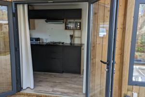 uma porta aberta para uma cozinha numa pequena casa em Mobil-home Camping Biscarosse em Biscarrosse