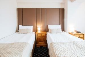 グラ・フモルルイにあるベスト ウエスタン ブコヴィナ クラブ デ ムンテのベッド2台が隣同士に設置された部屋です。