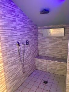 a bathroom with a shower with purple tiles at The Golden Palm - City Retreat in Aci Castello