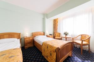 Best Western Bucovina Club de Munte في جورا هومورولوي: غرفة فندقية بسريرين وطاولة وكراسي