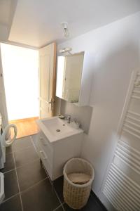 a white bathroom with a sink and a mirror at La Glycine Maison 1.5 km Veulettes sur mer in Paluel