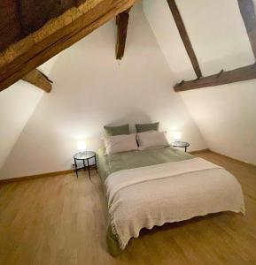 - une chambre mansardée avec un grand lit dans l'établissement Atypique - Centre historique - Appartement 2 chambres, à Bourges