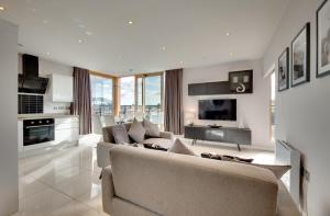 a living room with a couch and a tv at Amazing City Centre Penthouse With Private Roof Terrace in Newcastle upon Tyne