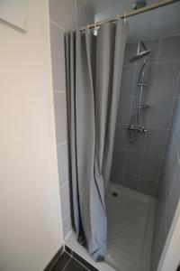 a shower with a white shower curtain in a bathroom at La Glycine Maison 1.5 km Veulettes sur mer in Paluel
