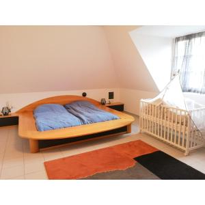 een slaapkamer met een houten bed en een wieg bij Haus am Stadtrand / Grünruhelage in Wenen