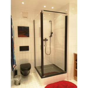 W łazience znajduje się prysznic i czarna toaleta. w obiekcie Haus am Stadtrand / Grünruhelage w Wiedniu