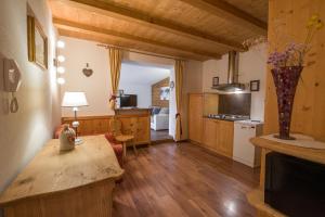 a kitchen with wooden floors and a table in a room at Appartamenti Sonnenuhr in Sesto