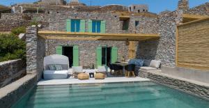 a villa with a swimming pool in front of a building at Kalma Living Luxury Villas in Kithnos