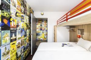 a bedroom with a bed and a wall of comics at hotelF1 Epinay sur Orge in Épinay-sur-Orge