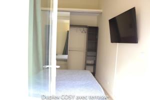 a room with a bed and a tv and a closet at Duplex cosy avec terrasse in Marseille