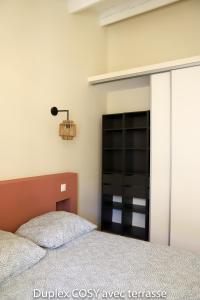 Un pat sau paturi într-o cameră la Duplex cosy avec terrasse