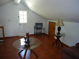 un soggiorno con 2 tavoli e una TV di Casa da Adega a Santo António