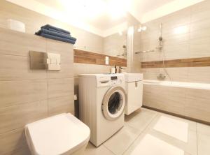 uma casa de banho com uma máquina de lavar roupa e um WC em Śliczna 34A by Homeprime em Cracóvia