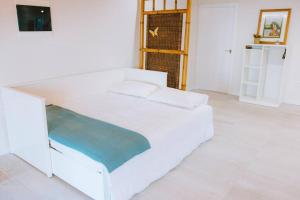 a white bedroom with a white bed and a television at Casita Gopal in Icod de los Vinos