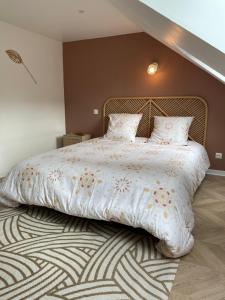 a large bed with a white comforter and pillows at Appartement L’opale d’Anaé in Boulogne-sur-Mer