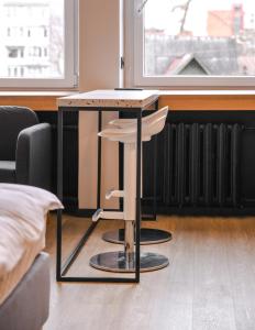 a table with a stool in a room at Apartments near Ozas in Vilnius