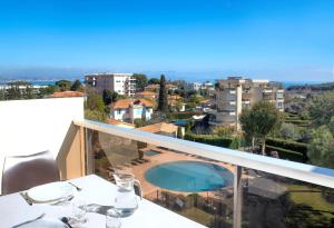 una mesa con copas de vino en un balcón con vistas en Residence Residéal Antibes, en Antibes