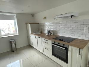 a kitchen with white cabinets and a stove top oven at Appartement L’opale d’Anaé in Boulogne-sur-Mer