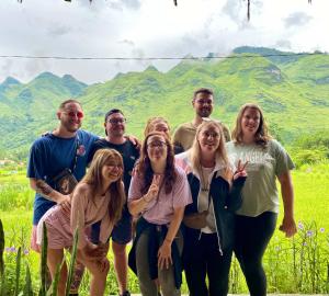 a group of people posing for a picture with mountains in the background at Du Gia Field View Homestay in Làng Cac