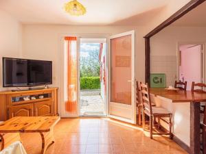 ein Wohnzimmer mit einem Tisch, einem TV und einem Esstisch in der Unterkunft Appartement Saint-Jean-de-Luz, 4 pièces, 5 personnes - FR-1-4-589 in Saint-Jean-de-Luz