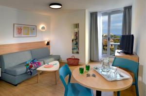 a living room with a couch and a table at Residence Residéal Antibes in Antibes