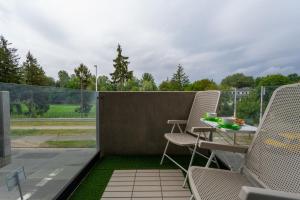 a patio with chairs and a table on a balcony at Marina Na Grobli Studio Apartments by Renters in Wrocław