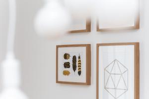 two framed pictures on a white wall with two crosses at Marina Na Grobli Studio Apartments by Renters in Wrocław