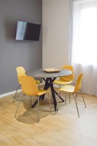 uma mesa de jantar com cadeiras amarelas à volta em Regina Apartment em Pescara
