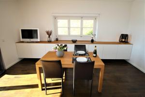 a kitchen with a wooden table with chairs and a television at Ferienwohnung SeeFugium in Tegernsee