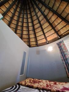 a bedroom with a bed and a wooden roof at Horizon View Chalets in Graskop