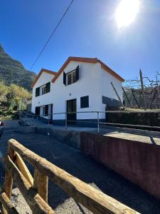 uma casa branca com uma cerca à frente. em The Passion Fruit House em São Vicente