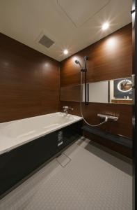 a bathroom with a bath tub and a sink at HOTEL SAILS in Osaka