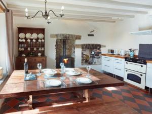 a kitchen with a wooden table and a fireplace at Glanceri in Sarnau
